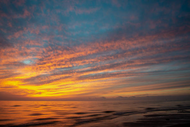 istock dramatic high contrast clouds in sunset over seaside beach 1084694640