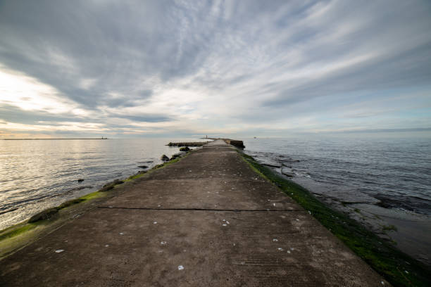 istock dramatic high contrast clouds in sunset over seaside beach 1084694736