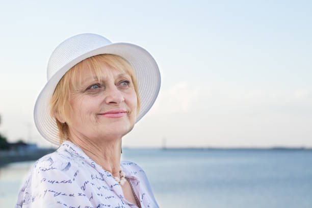 istock Happy smiling retired lady rests in nature near river 1084696648