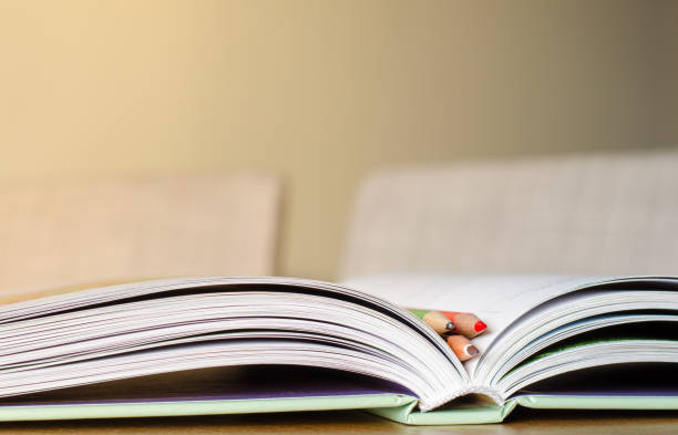 istock Three pencils in the open book. Reading and study theme background. 1084699158
