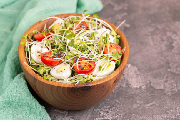 insalata leggera con germogli di ravanello, uova di quaglia, pomodorini e sesamo in ciotola di legno - balsamic vinegar vinegar salad spoon foto e immagini stock