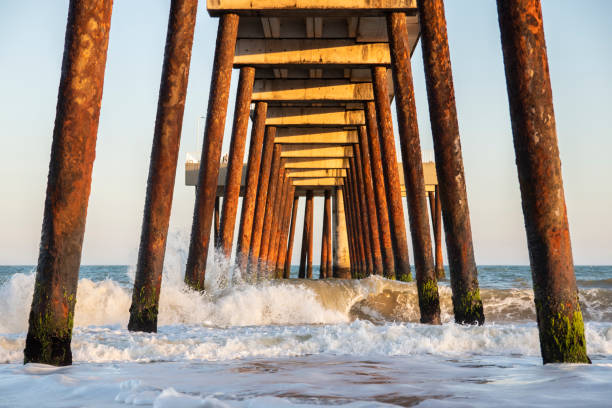 pier on the beach with crashing waves (costa azul, rio das ostras, rio de janeiro, brazil)