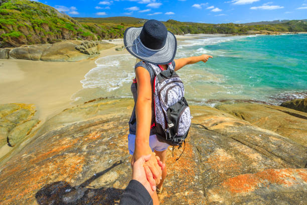 Follow me in Western Australia Follow me POV. Woman in hat holding hand of her friend at Waterfall Beach in Denmark, Western Australia. Backpacker at William Bay NP a popular Australian travel destination. antarctic ocean photos stock pictures, royalty-free photos & images