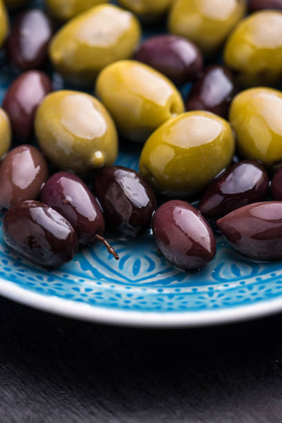 istock Green and dark olives on a blue greek plate. 1084703652