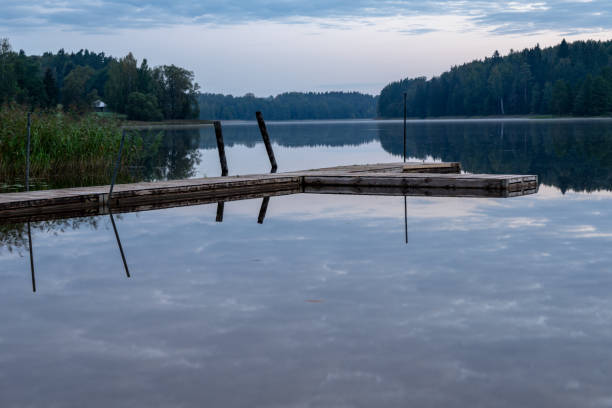 istock blue sky, clouds and trees from forest reflecting in calm lake water 1084704136