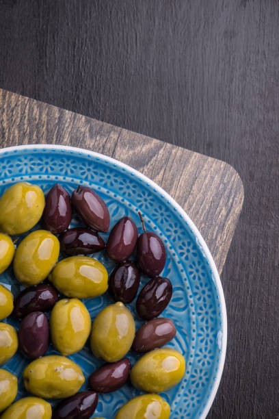 istock Green and dark olives on a blue greek plate. 1084704524