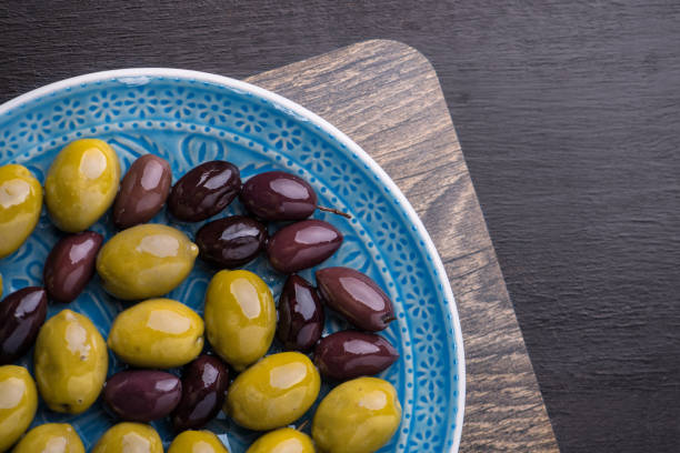 Green and dark olives on a blue greek plate.