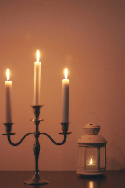 istock quiet home environment at night by candlelight. White candles burn in the dark. peaceful composition. 1084710560