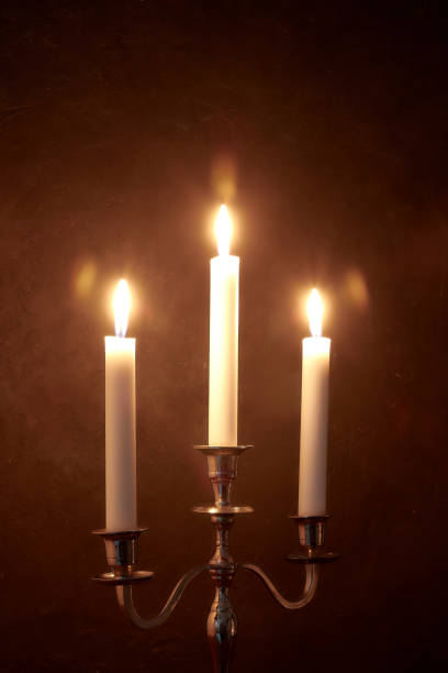 istock quiet home environment at night by candlelight. White candles burn in the dark. peaceful composition. 1084710574
