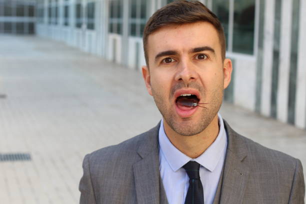 istock Businessman eating a big cockroach 1084728476