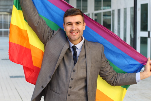Elegant man waving the gay flag.