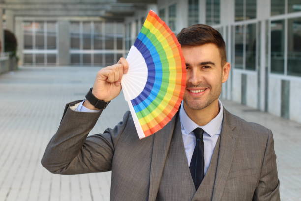homem elegante, acenando um fã gay - flag gay man american culture rainbow - fotografias e filmes do acervo