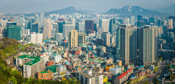 Aerial panoramic vista across the skyscrapers and landmarks, mountain parks and crowded suburbs of central Seoul, South Korea.