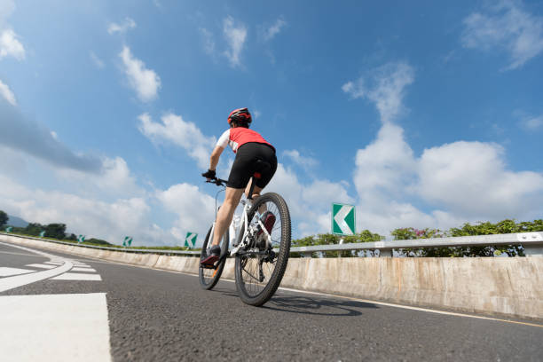 istock Woman cyclist riding Mountain Bike on highway 1084754792