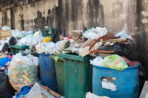 istock Stack of different types of large garbage dump, plastic bags, and trash bins near a wall in urban area in Environmental pollution concept in Bangkok city, Thailand 1084762694