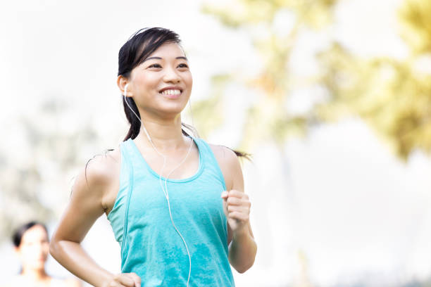 istock Smiling woman jogs in a city park 1084773884
