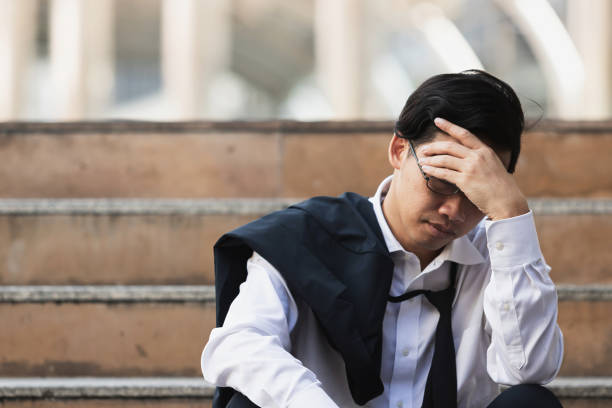 istock Unemployed stressed young Asian business man suffering from severe depression. Failure and layoff concept. 1084788616