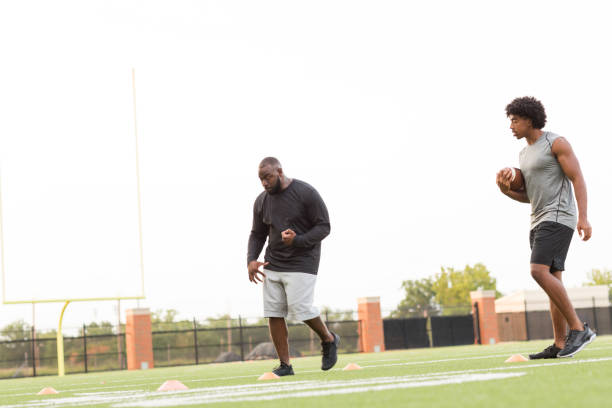 istock American Football coach training a young athlete. 1084788736