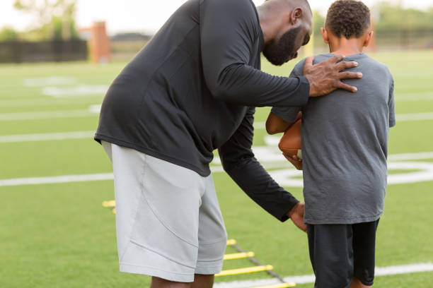 istock American Football coach training a young athlete. 1084788772