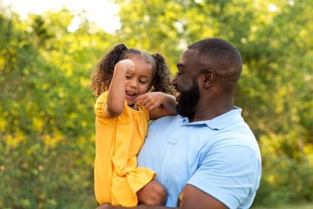 padre enseña a su hija a flexionar sus músculos. - flexing muscles fotografías e imágenes de stock