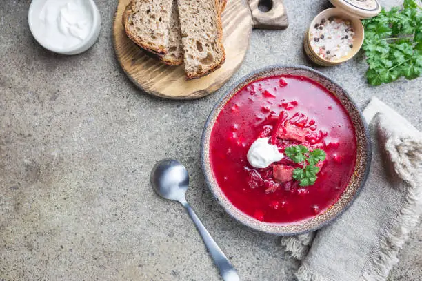 Beetroot soup: Traditional Ukrainian or Russian borscht with sour cream in a bowl, top view