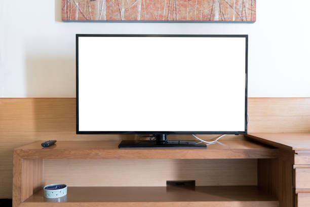 istock Mock up flat tv screen with remote panel on wwden shelf in living room at home. 1084800430