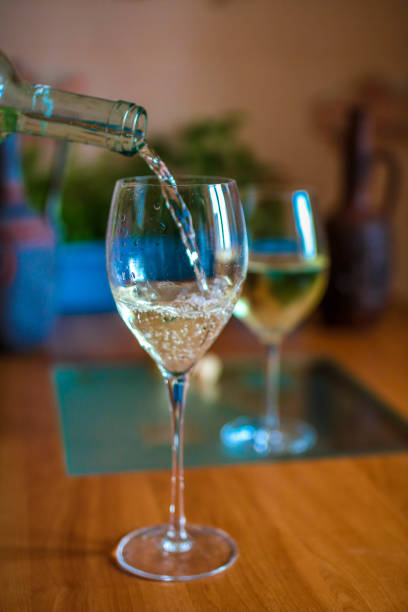 istock white wine pouring in to a glass from a bottle 1084803178