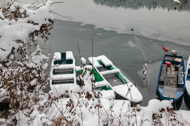 istock Boats on the frozen river covered with snow 1084808284