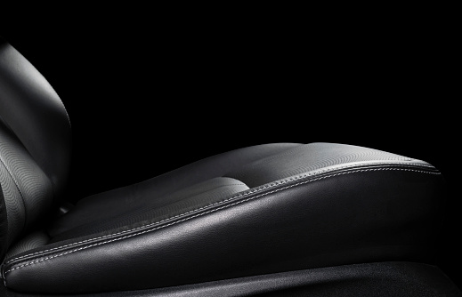 Car black leather interior. Part of leather car seat details with stitching. Interior of a car. Comfortable perforated leather seats. Black perforated leather. Car detailing