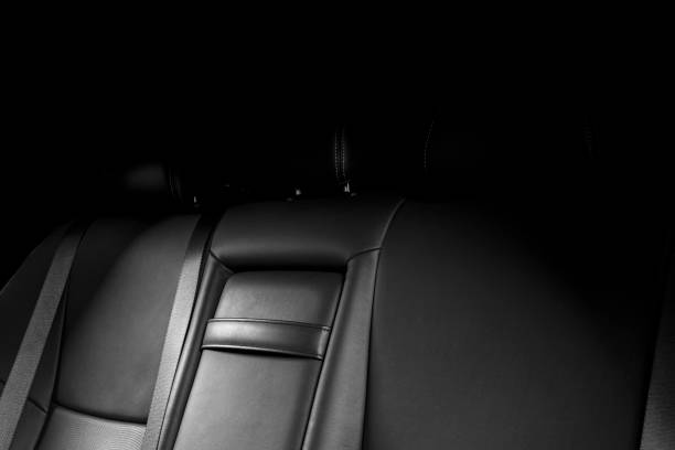 istock Back passenger seats in car, frontal view. Black perforated leather with white stitching. Car detailing. Leather comfortable black seats. Car interior details 1084812750