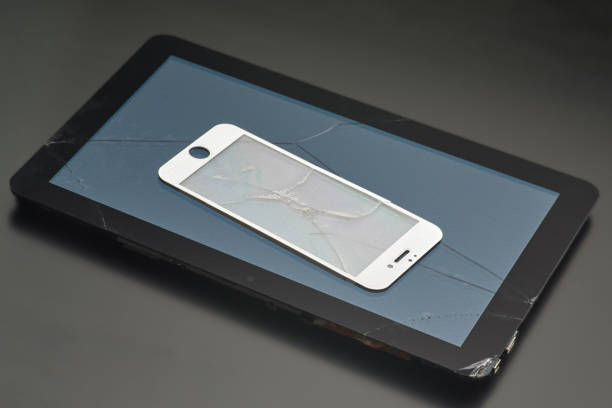 istock Broken tablet and broken protective glass from a smartphone, close-up 1084816024
