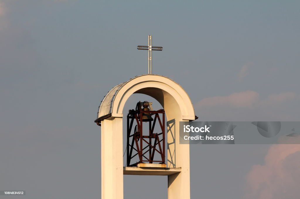 Moderna Torre Del Campanario De La Iglesia Católica Con Cruz De Hierro Y Grandes Llamada Mecanismo De Campana Al Atardecer Foto de stock y más banco de imágenes de Arquitectura - iStock Moderna Torre Del Campanario De La Iglesia Católica Con Cruz De Hierro Y Grandes Llamada Mecanismo De Campana Al Atardecer Foto de stock y más banco de imágenes de Arquitectura - iStock