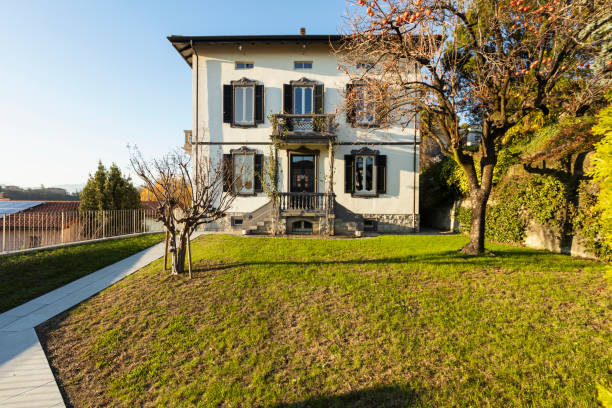 Exterior ancient villa with well-kept garden on a sunny day