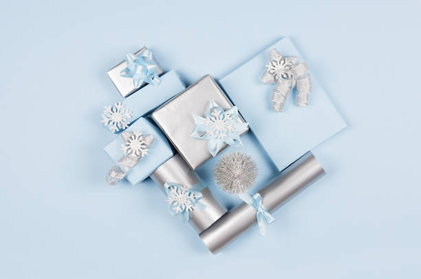 istock Modern soft minimalist heart shape - various blue and silver metallic gift boxes with shiny ribbons and bows on blue color backdrop, top view. Valentines day background. 1084843808