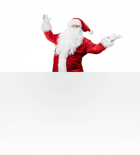istock Samta Claus jumping out behind the blank banner 1084844670