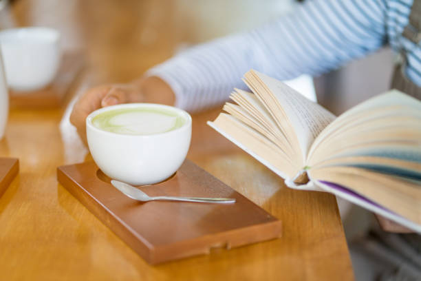 Woman drinking coffee while reading book