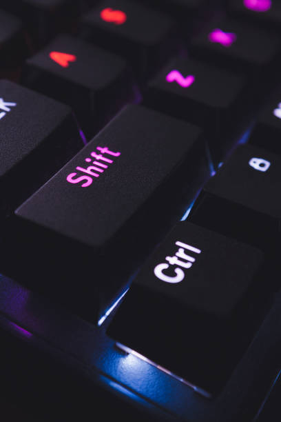 istock Black keyboard keys with colorful lights underneath, close up 1084845038