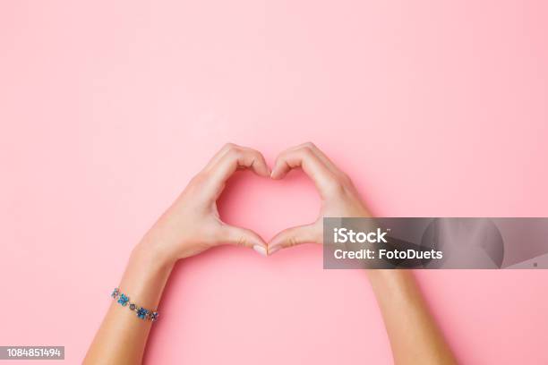 Heart Shape Created From Young Womans Hands On Pastel Pink Background Love And Happiness Concept Empty Place For Emotional Sentimental Text Quote Or Sayings Closeup Top View Stock Photo - Download Image Now