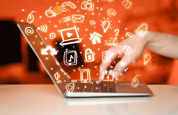 istock Hand writing on notebook computer with media icons and symbols 1084853086