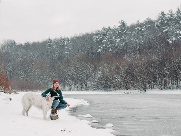 istock Woman and her dog having fun winter 1084853506