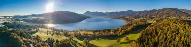 Beautiful Aerial Flight at the Tegernsee Lake in Bavaria Germany. Perfect autumn sunset with some fog in the forest
