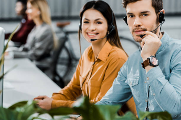 istock smiling call center operators in headsets looking at camera in office 1084862910