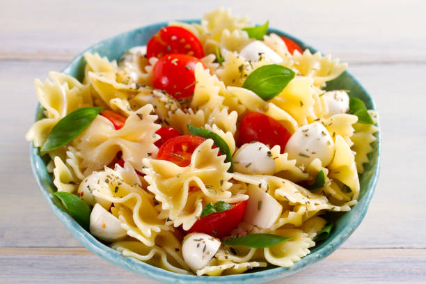 istock Caprese Pasta Salad. Pasta with mozzarella cheese, tomatoes and basil 1084863112