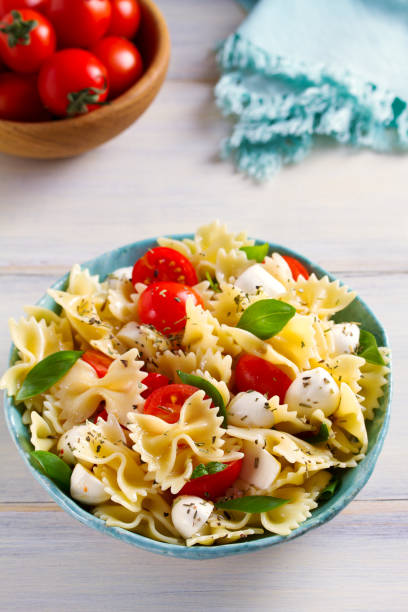 istock Caprese Pasta Salad. Pasta with mozzarella cheese, tomatoes and basil 1084864390