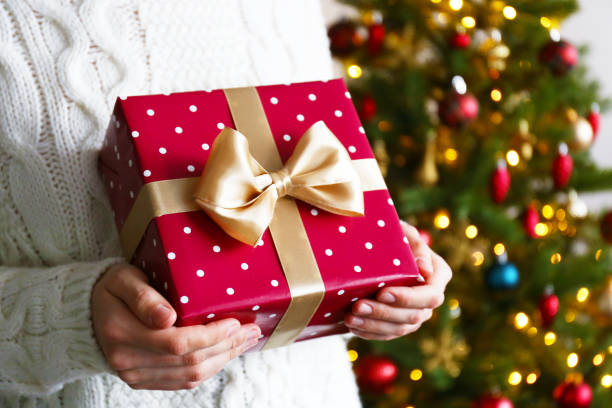 istock Young woman holding colorful present. 1084864654