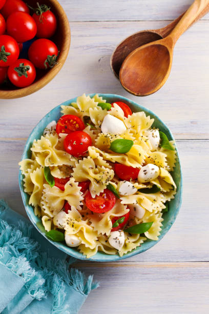 istock Caprese Pasta Salad. Pasta with mozzarella cheese, tomatoes and basil 1084865006