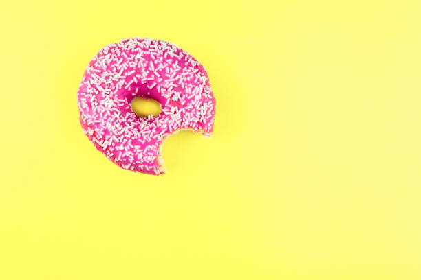 istock pink donut on color background. Flat lay 1084865254