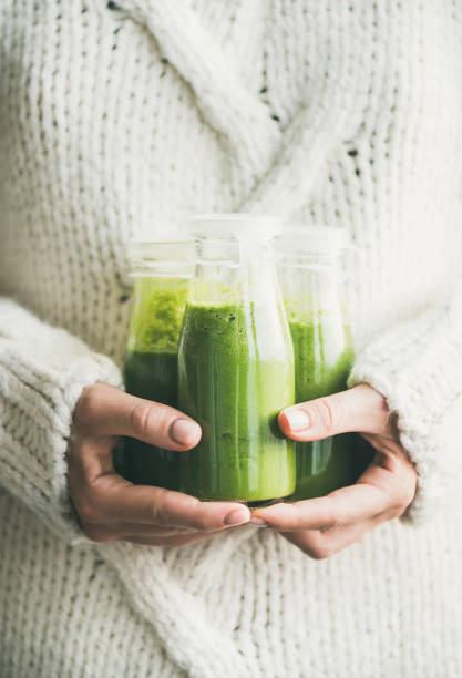 batido verde saludable o zumo en botellas en las manos mujer - healthy eating food and drink raw leek fotografías e imágenes de stock