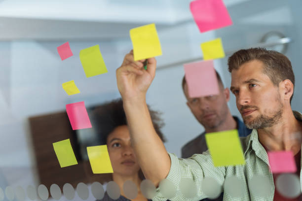 istock Coworkers discussing new ideas on a glass wall 1084870950