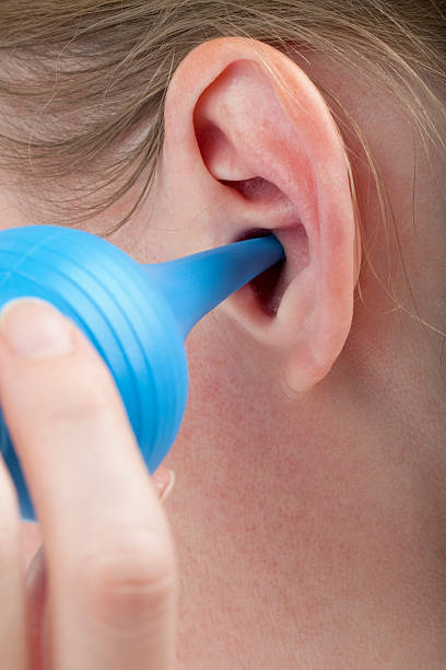 istock woman cleaning her ear canal with bulb syringe 108487554